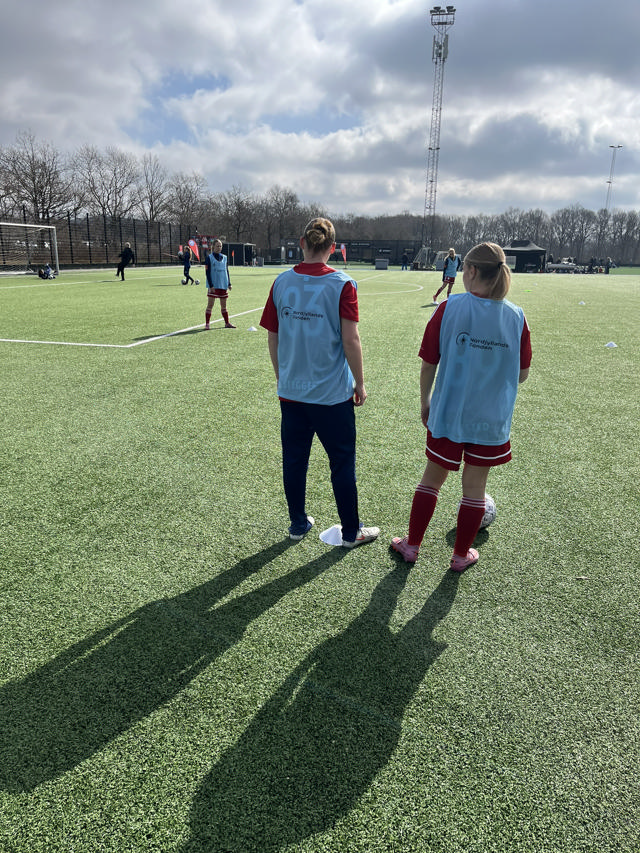 To fodboldpiger i lyseblå veste fra Nordjyllandsfonden